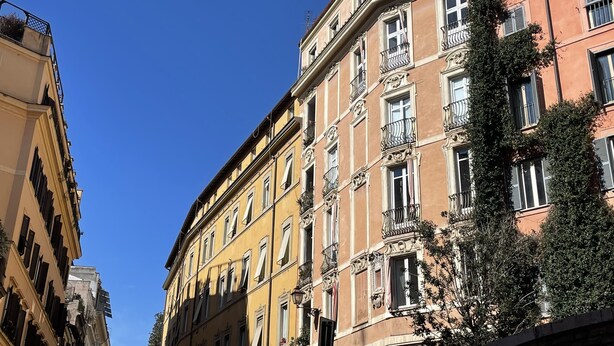 A multi-story building with balconies and a clear blue sky. - Monti Apartments - M5 (Rome)
