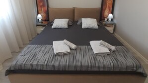 Un lit bien fait, avec une couvre-lit à motifs, deux oreillers et deux lampes de chevet.