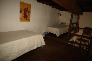 A room with a single bed, a smaller bed, a chair, and a painting on the wall. - Castel D'Arno THE KITCHEN Apt (Perugia)