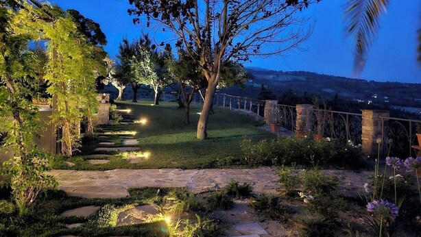 A garden pathway with stone steps and greenery, leading to a large tree and a view of a distant landscape. - Castel D'Arno THE KITCHEN Apt (Perugia)