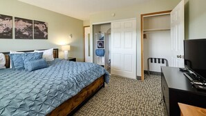 A hotel room with a bed, a desk, a television, and a wardrobe. - King Suite - Top Floor - Ocean View - Beach Access - Pool & Hot Tub! (Lincoln City)