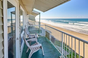 Ein Balkon mit Blick auf Strand und Meer.