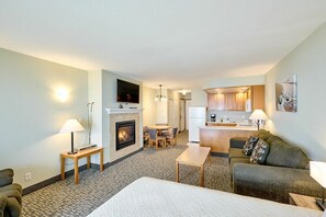 A hotel room with a fireplace, a sofa, a dining table, and a kitchen area. - Top Floor Family Suite with Fireplace and Kitchen - Beach Access - Beautiful Ocean Views! (Lincoln City)