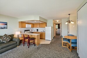 A compact living space with a kitchenette, a dining area, and a sofa.