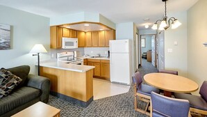 Un espacio habitable compacto con kitchenette, comedor y sofá.