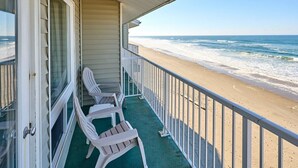 A beachfront property with a balcony, white plastic chairs, and a view of the ocean. - Deluxe Ocean View Family Suite - Sleeps Six - Heated Pool & Hot Tub! (Lincoln City)