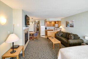 Ein Hotelzimmer mit Küchenzeile, Essbereich, einer Couch und einem Bett.