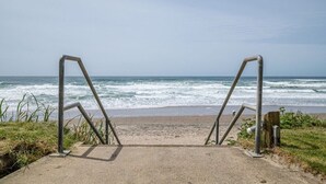 A concrete pathway leading to a beach with metal railings. - Stunning Top Floor Corner Suite for 6! Beautiful Ocean Views & Easy Beach Access! (Lincoln City)