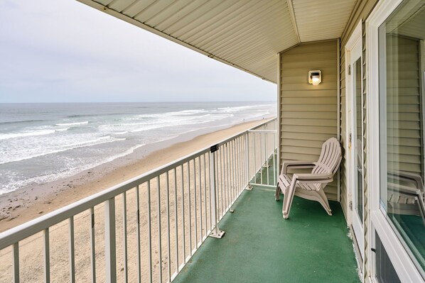 A balcony with a view of the beach and ocean.