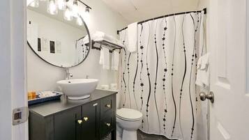 Een bad/douchecombinatie, een haardroger, handdoeken, shampoo