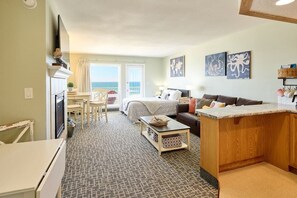 A room with a bed, a sofa, a dining table, and a television. - Amazing Ocean View Suite - Sleeps Six - Pool Access & Hot Tub! (Lincoln City)