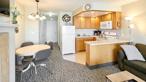 A compact kitchen with a central island, a dining area with a round table and chairs, and a living area with a sofa and a coffee table. - Ocean View Suite - Sleeps Six - Heated Indoor Pool & Hot Tub Access (Lincoln City)