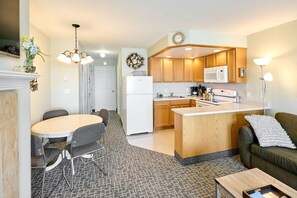 A compact kitchen with a central island, a dining area with a round table and chairs, and a living area with a sofa and a coffee table. - Ocean View Suite - Sleeps Six - Heated Indoor Pool & Hot Tub Access (Lincoln City)