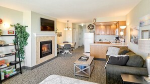 A living room with a fireplace, a sofa, a coffee table, and a TV. - Ocean View Suite - Sleeps Six - Heated Indoor Pool & Hot Tub Access (Lincoln City)