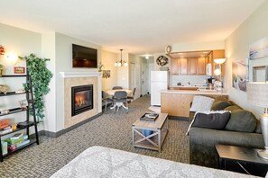 A living room with a fireplace, a sofa, a coffee table, and a TV. - Ocean View Suite - Sleeps Six - Heated Indoor Pool & Hot Tub Access (Lincoln City)