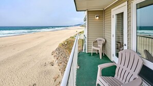 A beachfront property with a covered porch, a chair, and a view of the ocean.