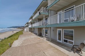 Un hôtel situé en bord de mer, doté de nombreux balcons, d’une promenade en béton et offrant une vue sur l’océan.