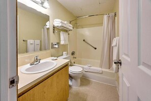 Une salle de bain comprenant un lavabo, des toilettes et un espace douche.