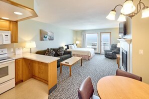 Une chambre d’hôtel équipée d’une kitchenette, d’un canapé, d’un lit, d’un coin repas et d’un balcon avec vue.