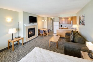 Ein Hotelzimmer mit Kamin, Essbereich, Küche und Wohnbereich.