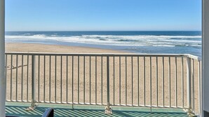 A beach view from a balcony with a railing, clear sky, and ocean waves. - Oceanfront Suite - King Bed - Heated Indoor Pool & Hot Tub (Lincoln City)