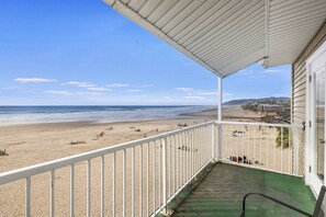 En balkon med udsigt over strand og hav.