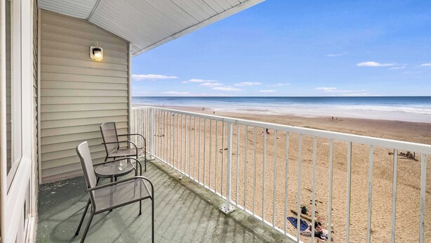 A balcony with a view of the beach, metal chairs, and a small table. - Corner King Suite, Stunning Ocean and River Views! (Lincoln City)