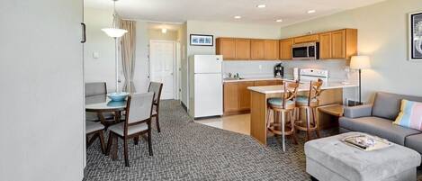 Un espace de vie compact comprenant une kitchenette, un coin repas et un coin salon.