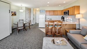 Una habitación de hotel compacta con kitchenette, comedor y sala de estar.