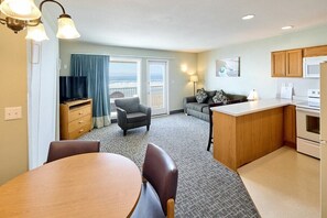 A compact living space with a dining area, kitchenette, and a balcony with a view. - Oceanfront Family Suite - Full Kitchen - Easy Beach Access! (Lincoln City)