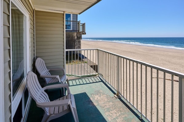 Ein Balkon mit zwei Stühlen und Blick auf den Strand.