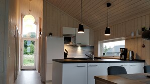 A modern kitchen with white cabinetry, a black countertop, and pendant lighting. - Danish coziness on the Wadden Sea - family and dog friendly. (Jade)