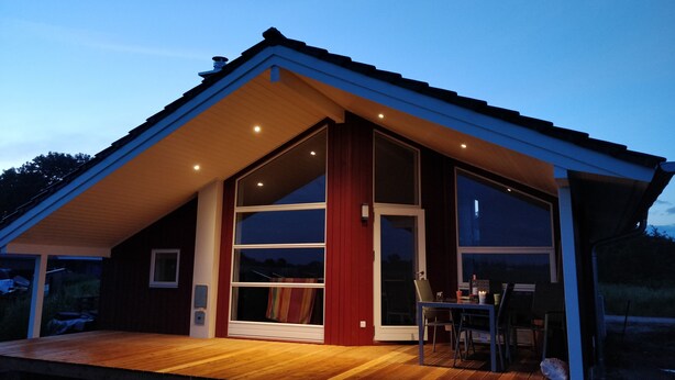A modern house with a large deck, large windows, and a sloped roof. - Danish coziness on the Wadden Sea - family and dog friendly. (Jade)