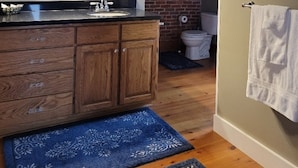 A modern bathroom with a wooden vanity, a large mirror, and a light fixture above the sink. - Haven Point is Spacious and Great for Families.  2nd floor apartment. (Strawberry Point)