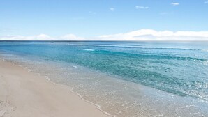 Una spiaggia con acque cristalline e una battigia sabbiosa.