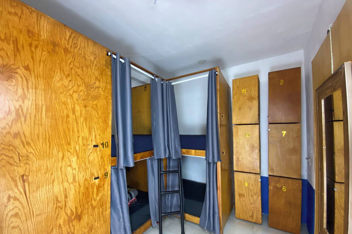 Ein Zimmer mit Stockbetten, Holzschränken und einer Himmelsleiter.