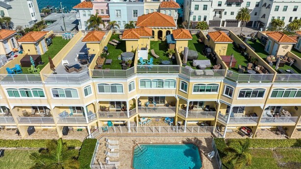 A multi-story hotel with balconies, a swimming pool, and a marina view. - Stunning Waterfront Penthouse with Rooftop Casita – Steps to Clearwater Beach (Clearwater)