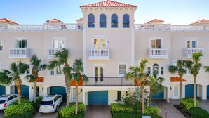 A multi-story hotel with balconies, palm trees, and a parking area. - Stunning Waterfront Penthouse with Rooftop Casita – Steps to Clearwater Beach (Clearwater)