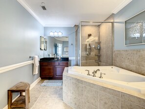 Een bad/douchecombinatie, een bubbelbad, een haardroger, handdoeken