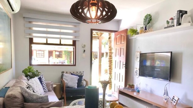 A modern living room with a sofa, coffee table, and TV. - Beautiful, cozy, and well-equipped - Geribá within walking distance! (Armação dos Búzios)