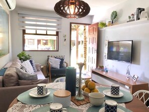 Un salon moderne avec un canapé, une table basse et un téléviseur.