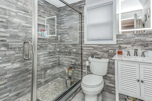 シャワー付き浴槽、タオル、石鹸、トイレットペーパー