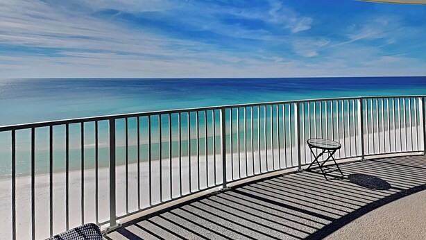 Ein Balkon mit Blick auf den Ozean und den Strand.