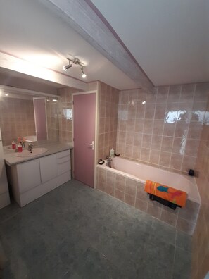 Bathtub, hair dryer, towels, toilet paper