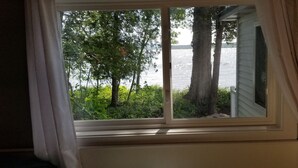 A window with a view of a lake and trees.