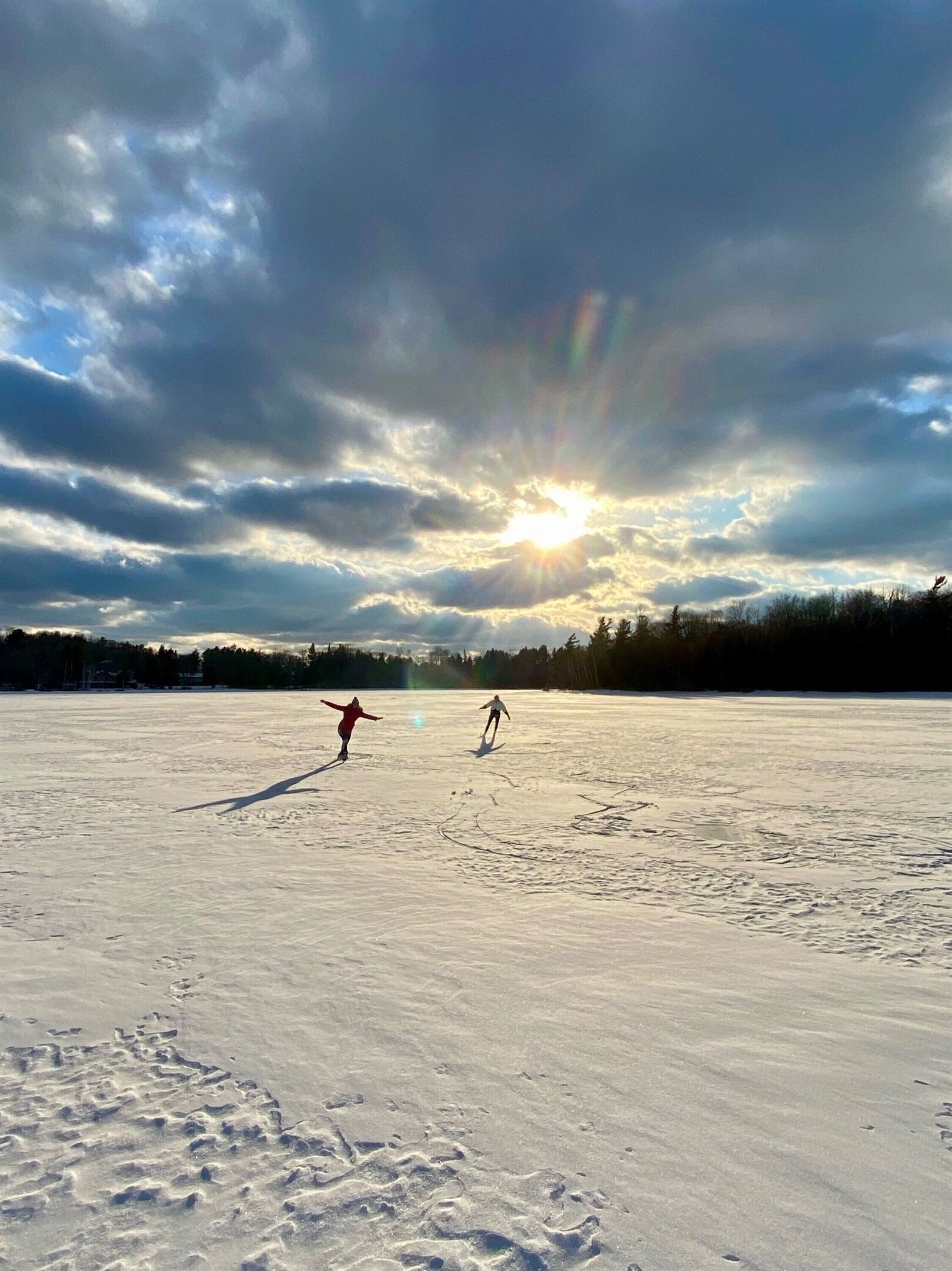 Een besneeerd landschap met twee personen aan het skiën.