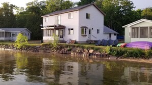 A two-story house with a porch and a small attached structure.