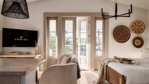 A modern bedroom with a bed, a TV, a desk, and a chair. - Villa Rosé - Private pool near Rosemary Beach (Rosemary Beach)