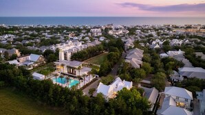 An aerial view of a residential area with houses, a swimming pool, and a view of the ocean. - Villa Rosé - Private pool near Rosemary Beach (Rosemary Beach)