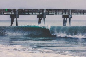 A pier extending into the ocean with waves crashing against it.